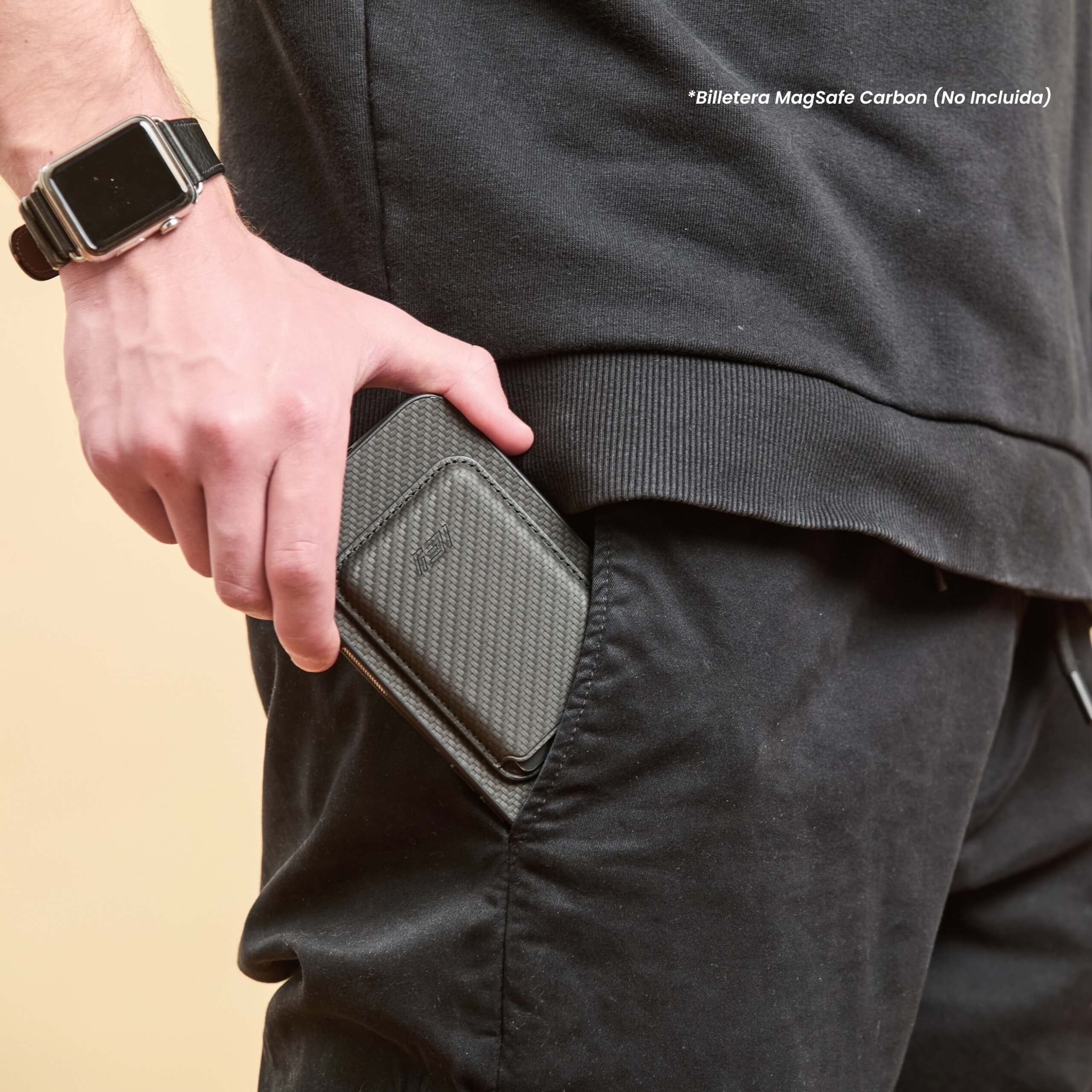 Funda IEY negra con billetera MagSafe acoplada, siendo guardada en el bolsillo del pantalón #color_negro