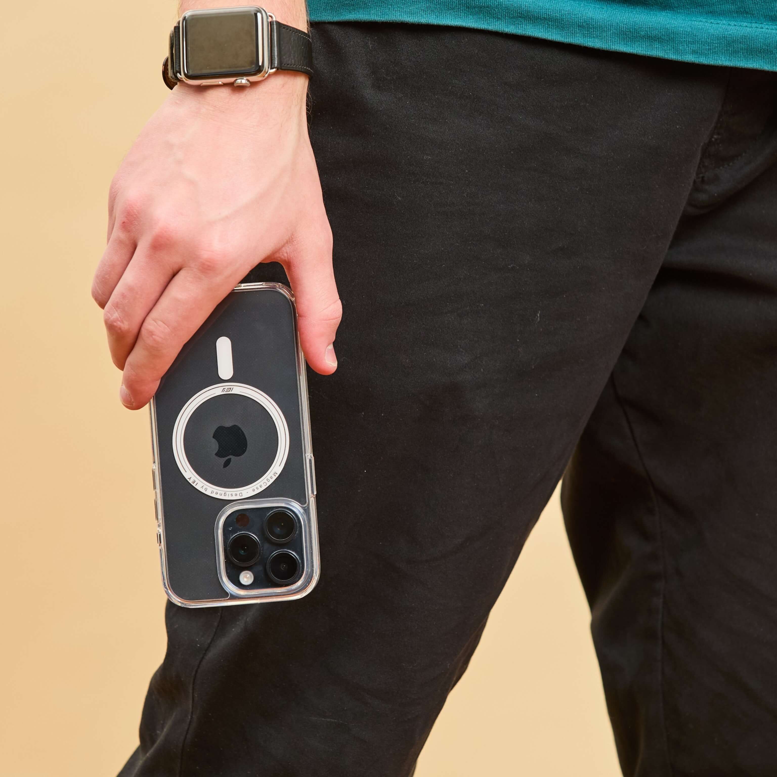 Persona caminando con iPhone en mano usando funda MagSafe transparente, diseño premium visible desde vista inferior