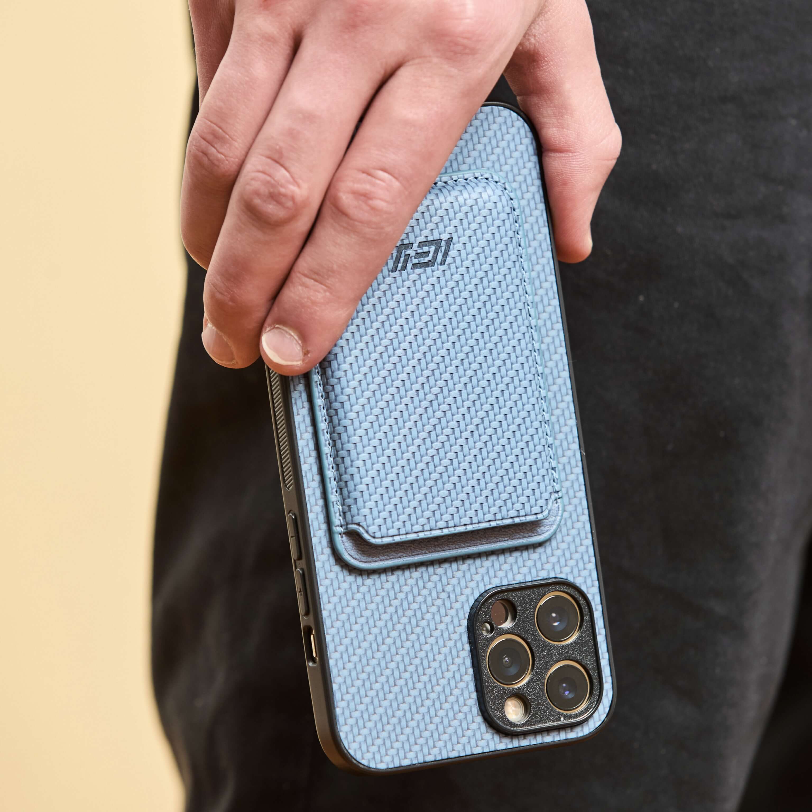 Primer plano de mano masculina sosteniendo el combo MagSafe azul, destacando textura y diseño del producto. #color_azul