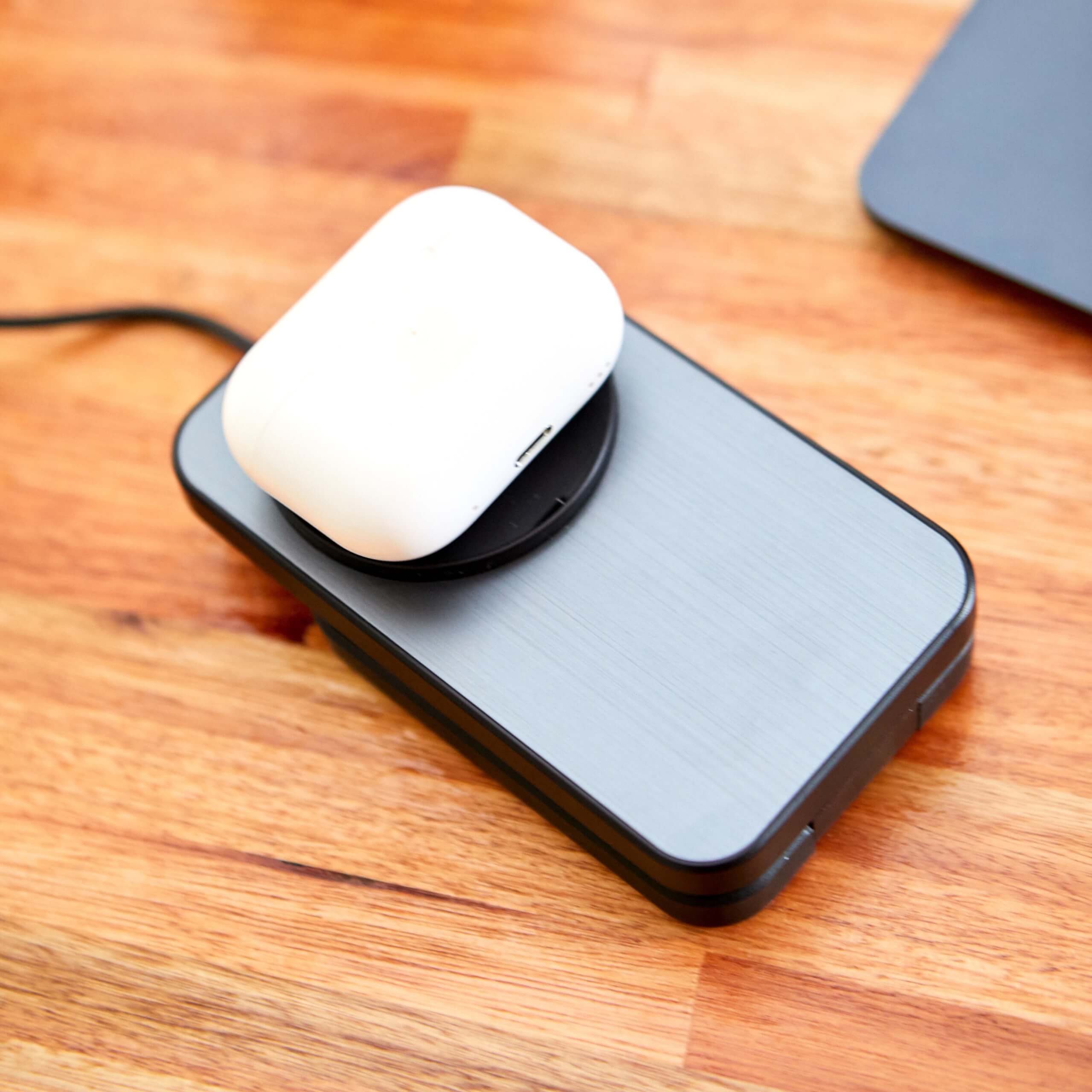Base de carga inalámbrica con AirPods sobre superficie de madera