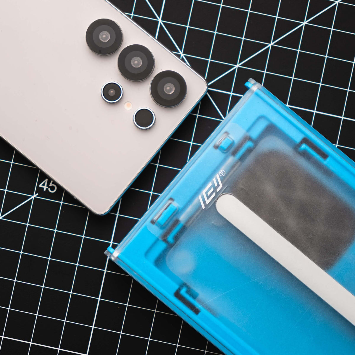Fotografía de Samsung Galaxy junto al aplicador azul ApplyFit™ de IEY®, sistema para instalar vidrio templado de forma guiada.