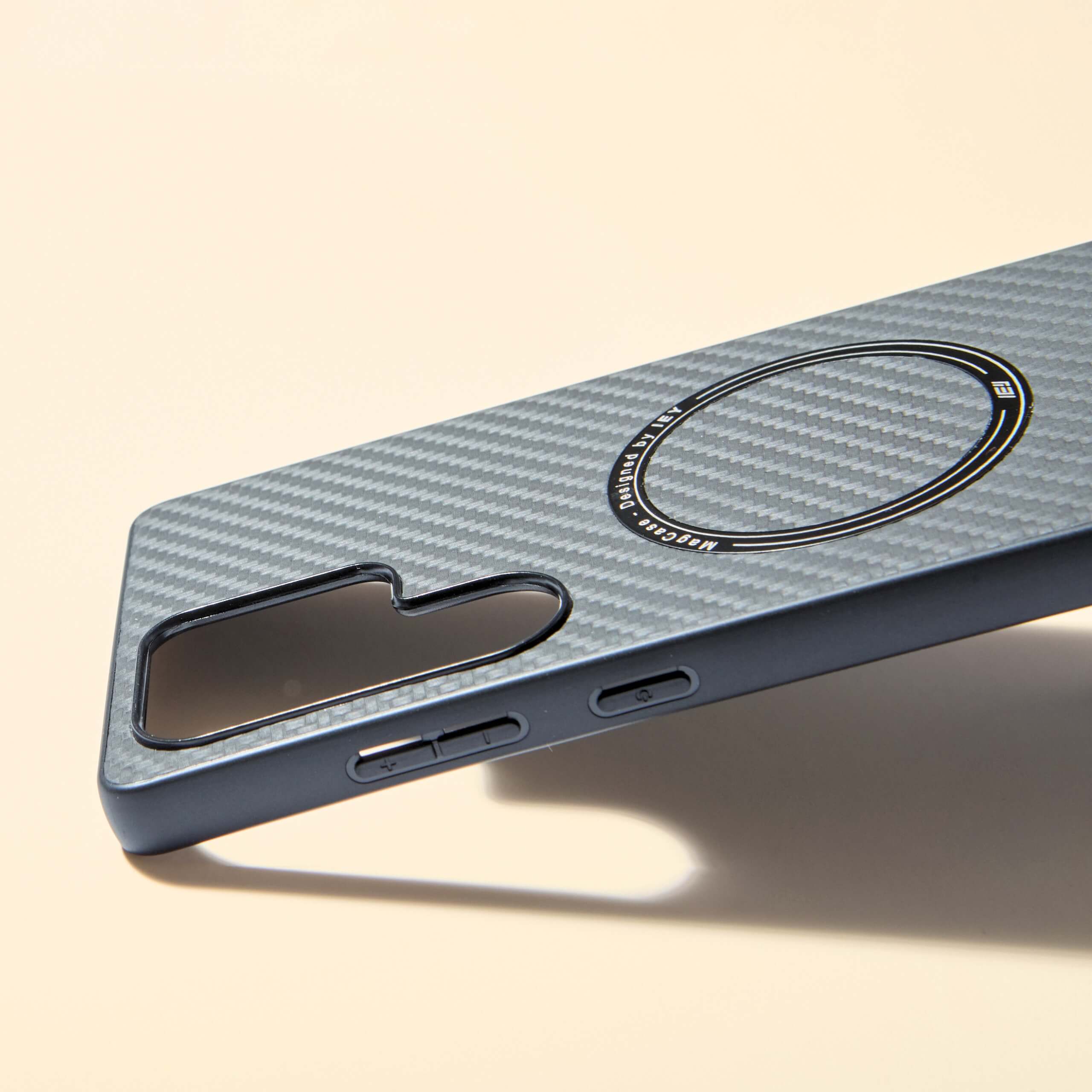 Funda MagSafe negra Samsung con textura tipo fibra de carbono, vista diagonal con aro imantado grabado y diseño ultraligero #color_negro