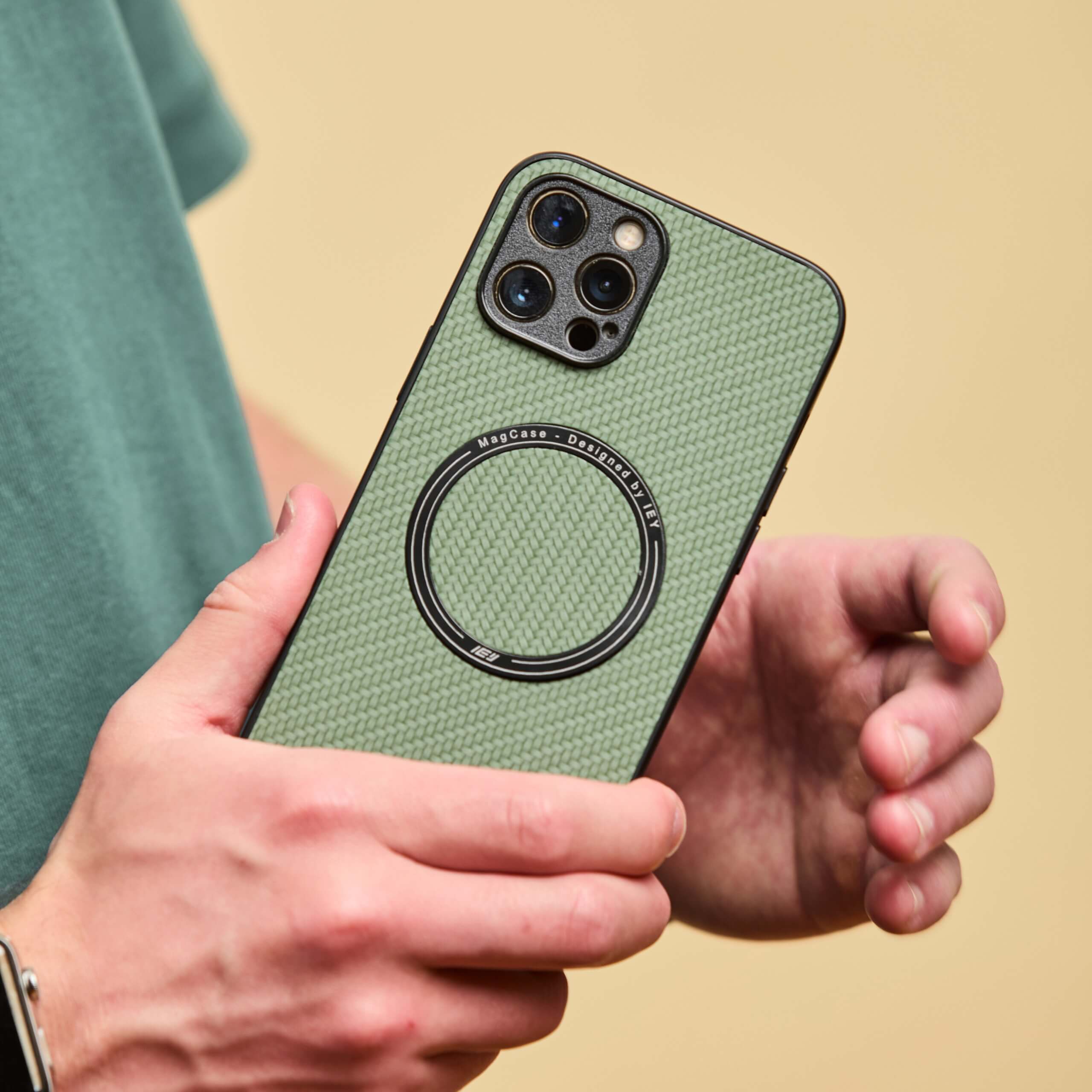 Hombre sosteniendo un iPhone con funda MagSafe verde de IEY.