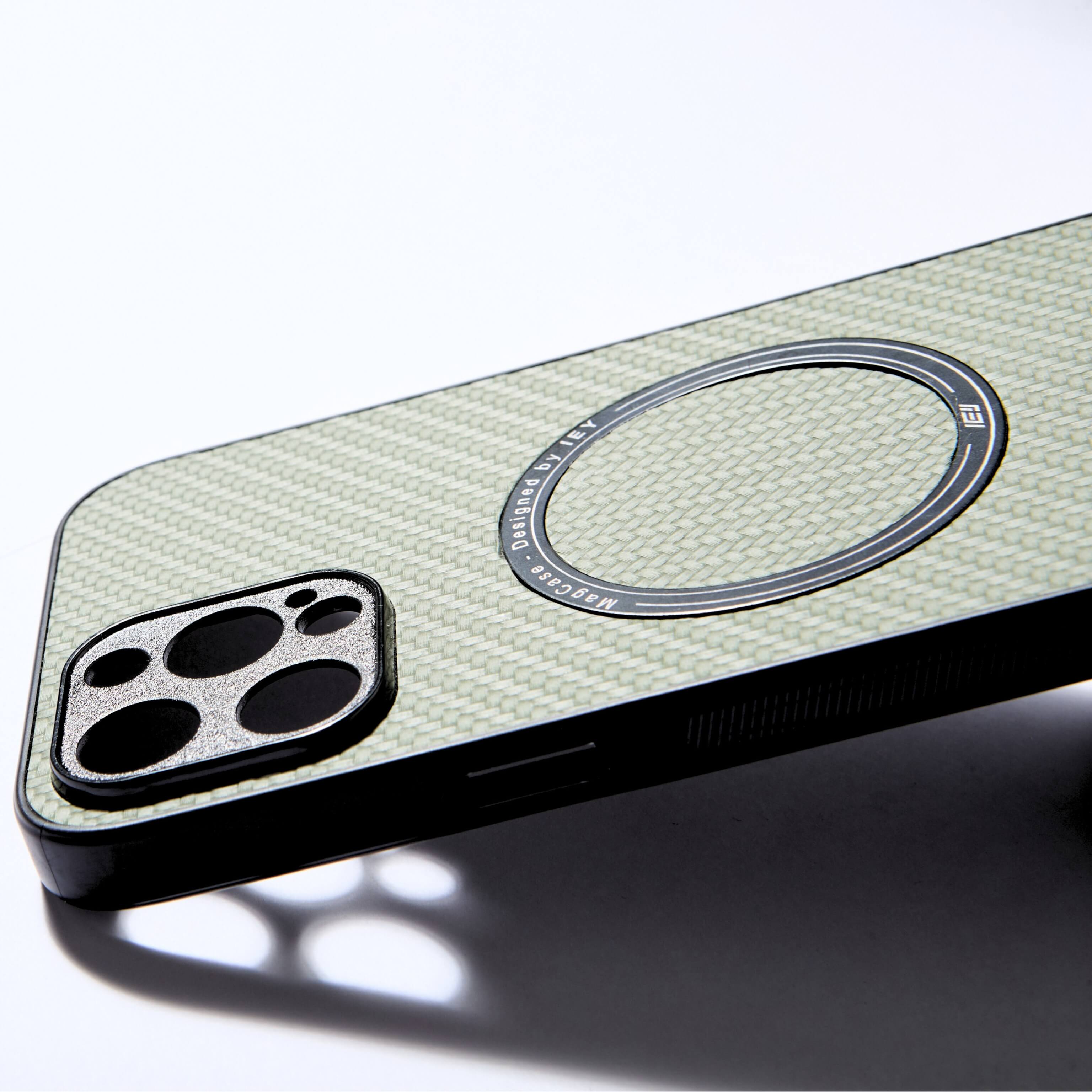 Funda MagSafe verde con textura tipo fibra de carbono, vista diagonal con aro imantado grabado y diseño ultraligero #color_verde