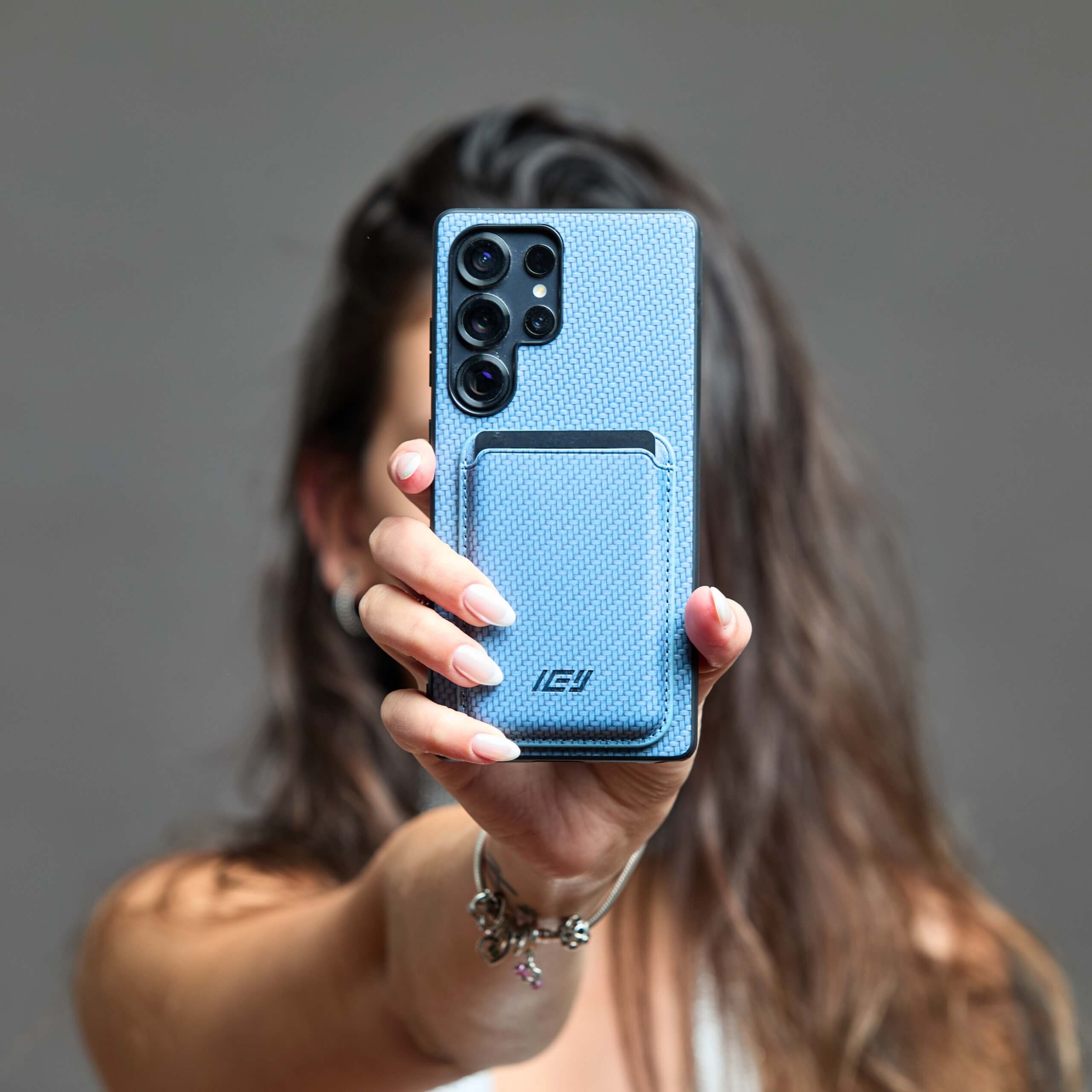 Combo MagSafe azul claro sostenido en manos, en posición horizontal, destacando su fijación magnética. #color_azul