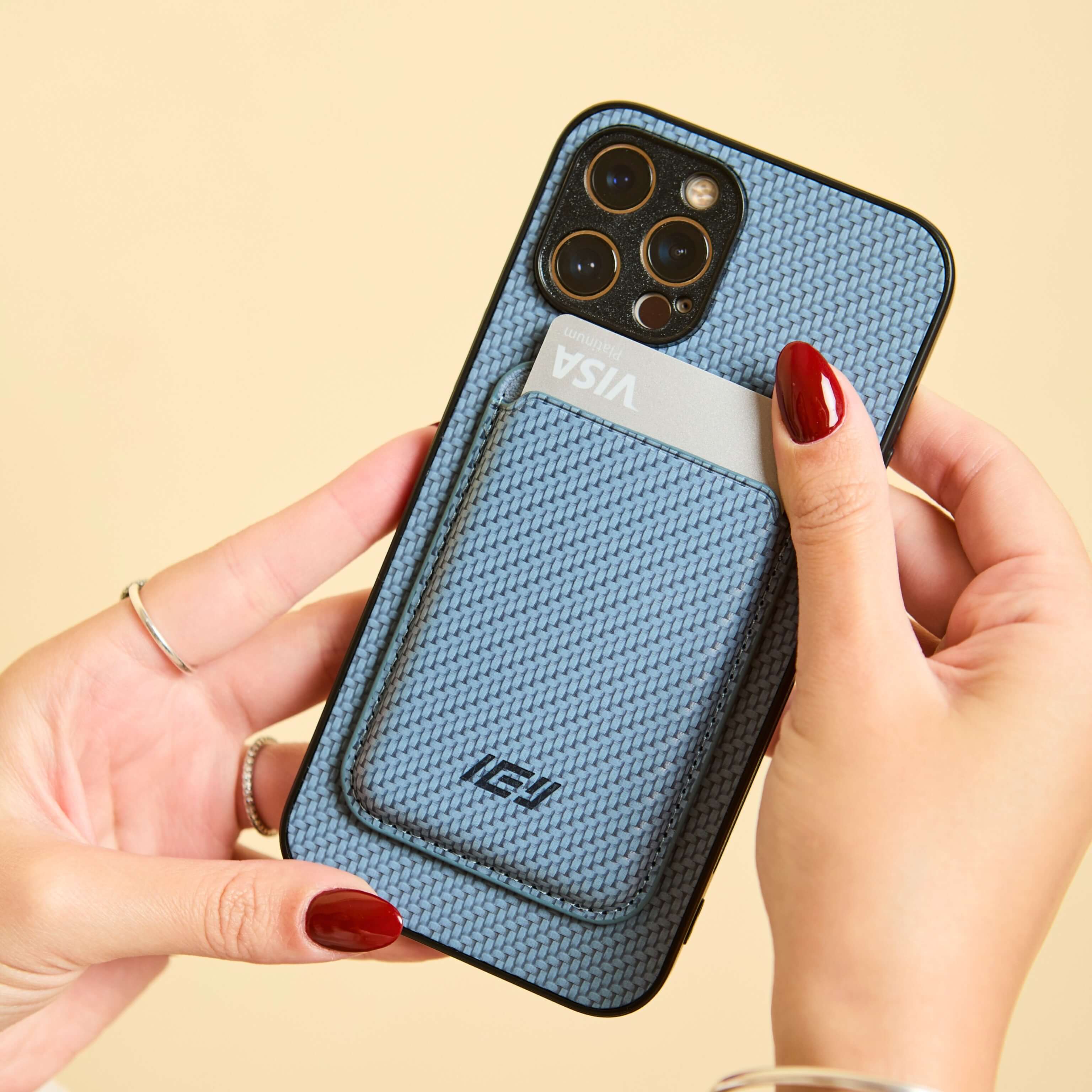 Manos mostrando la funda y billetera MagSafe azul claro en posición vertical, enfocando detalles y textura. #color_azul