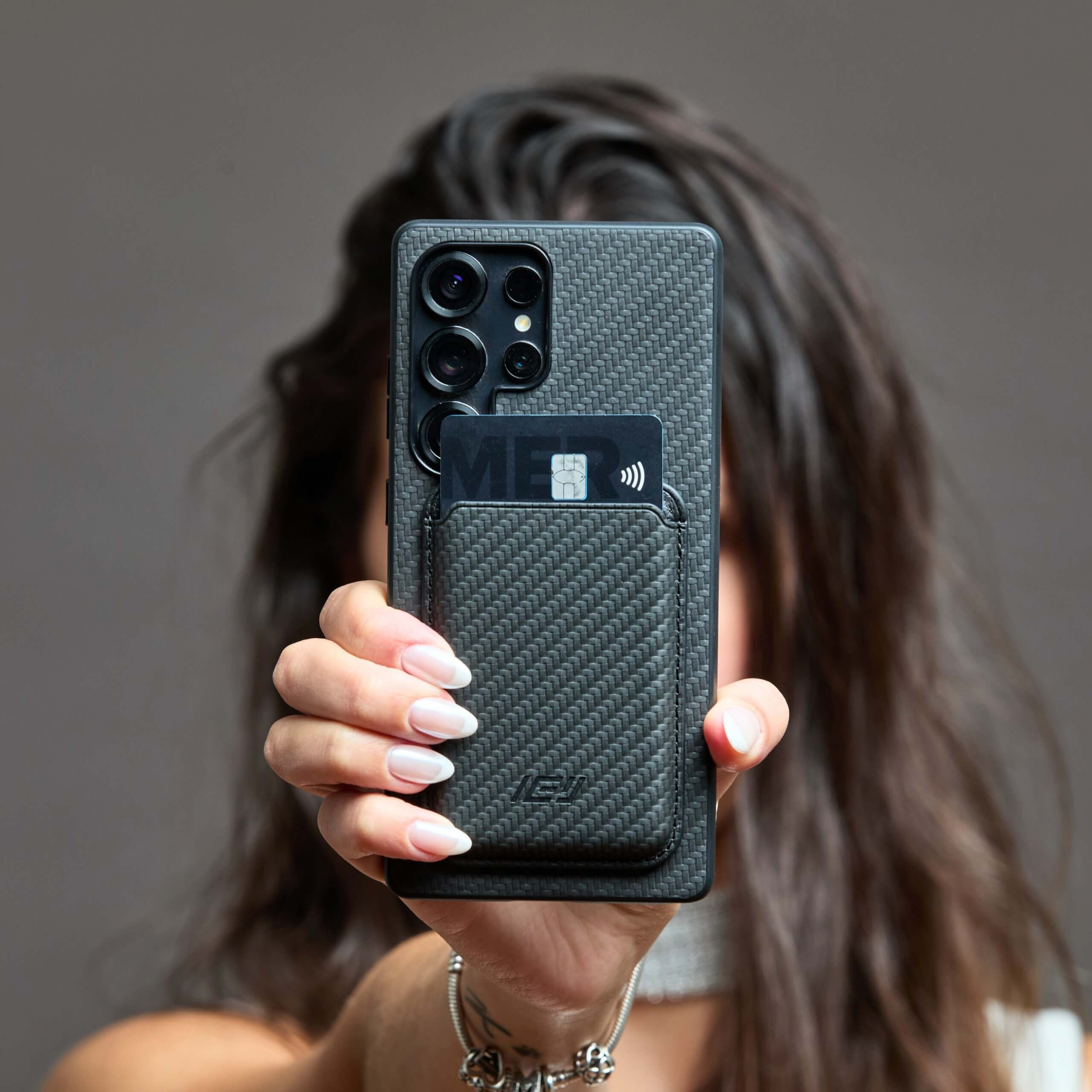 Funda MagSafe IEY® negra carbon con wallet, vista trasera en mano #color_negro