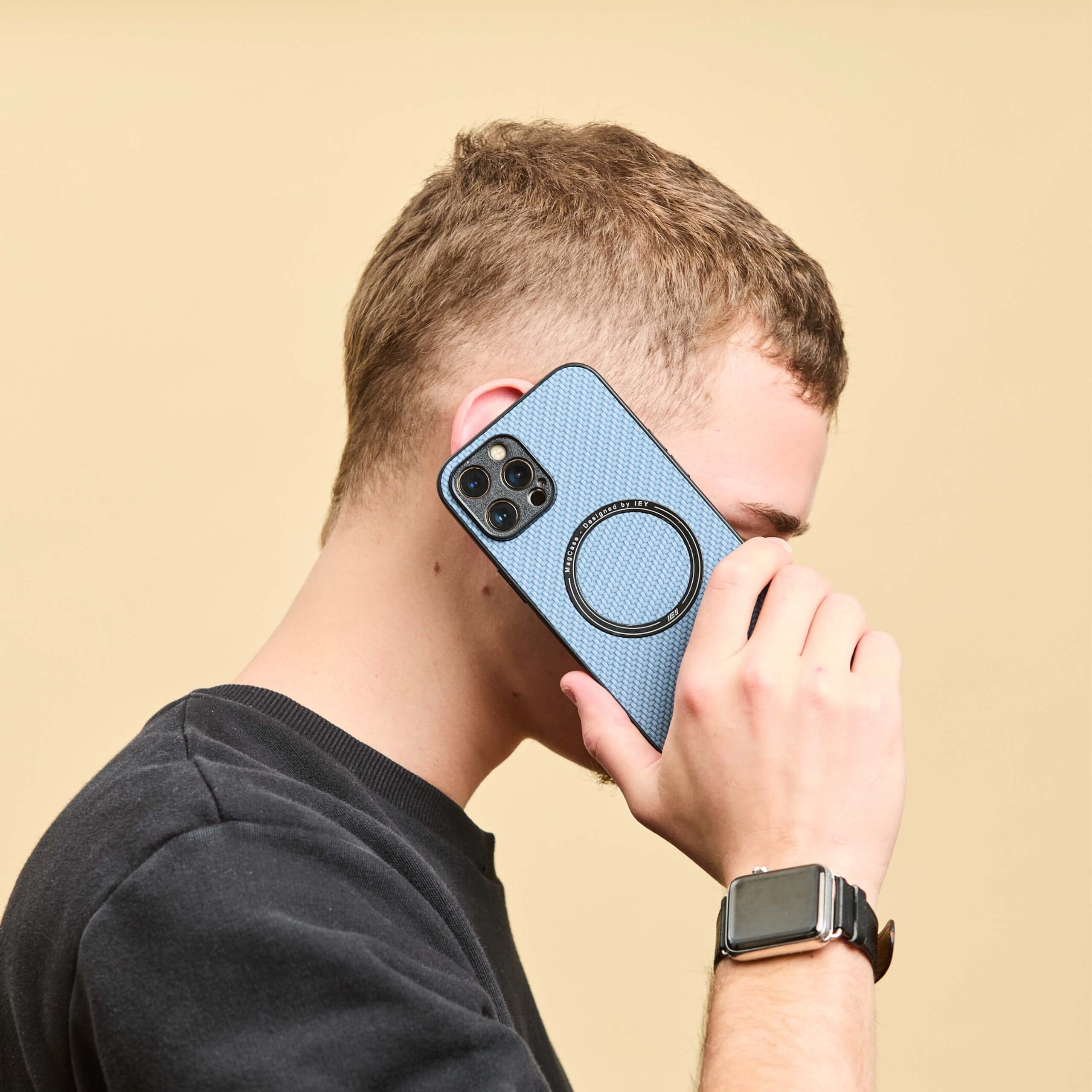 Hombre usando iPhone con funda MagSafe azul durante una llamada.