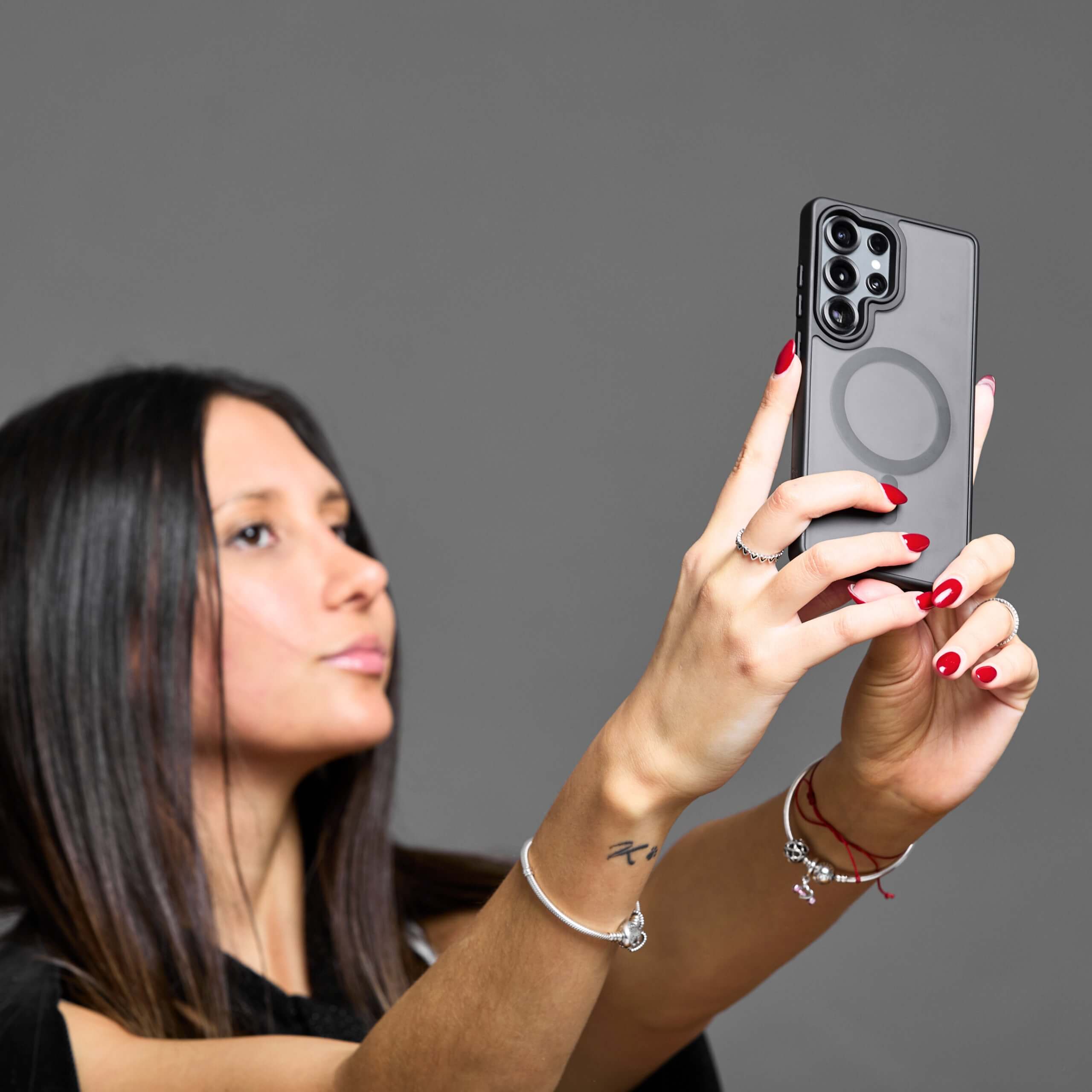 Mujer tomando una selfie con funda MagSafe negra en su Samsung Galaxy.