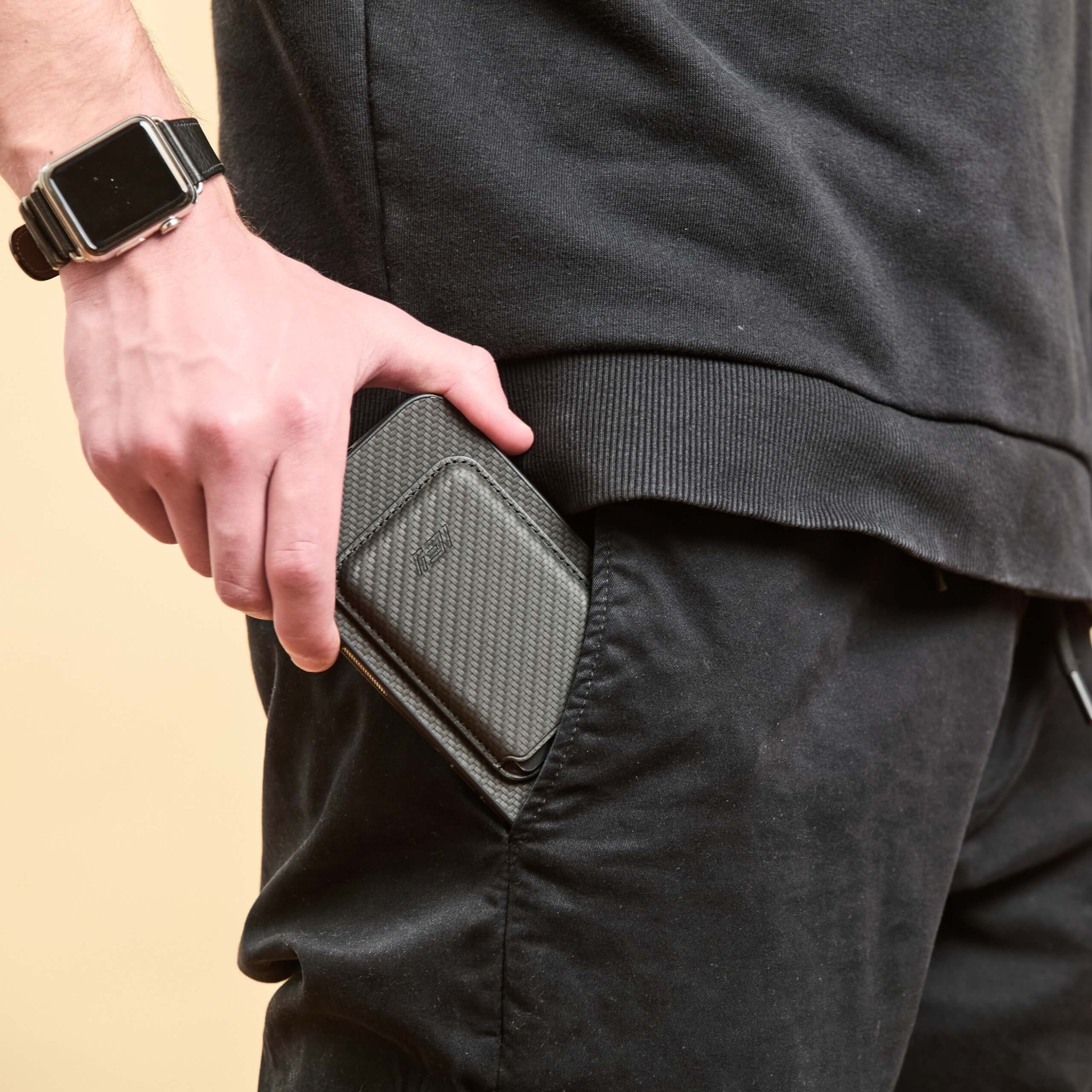 Hombre sacando su Iphone con la Funda Magsafe con Billetera MagWallet color negro del bolsillo lateral de su jean #color_negro