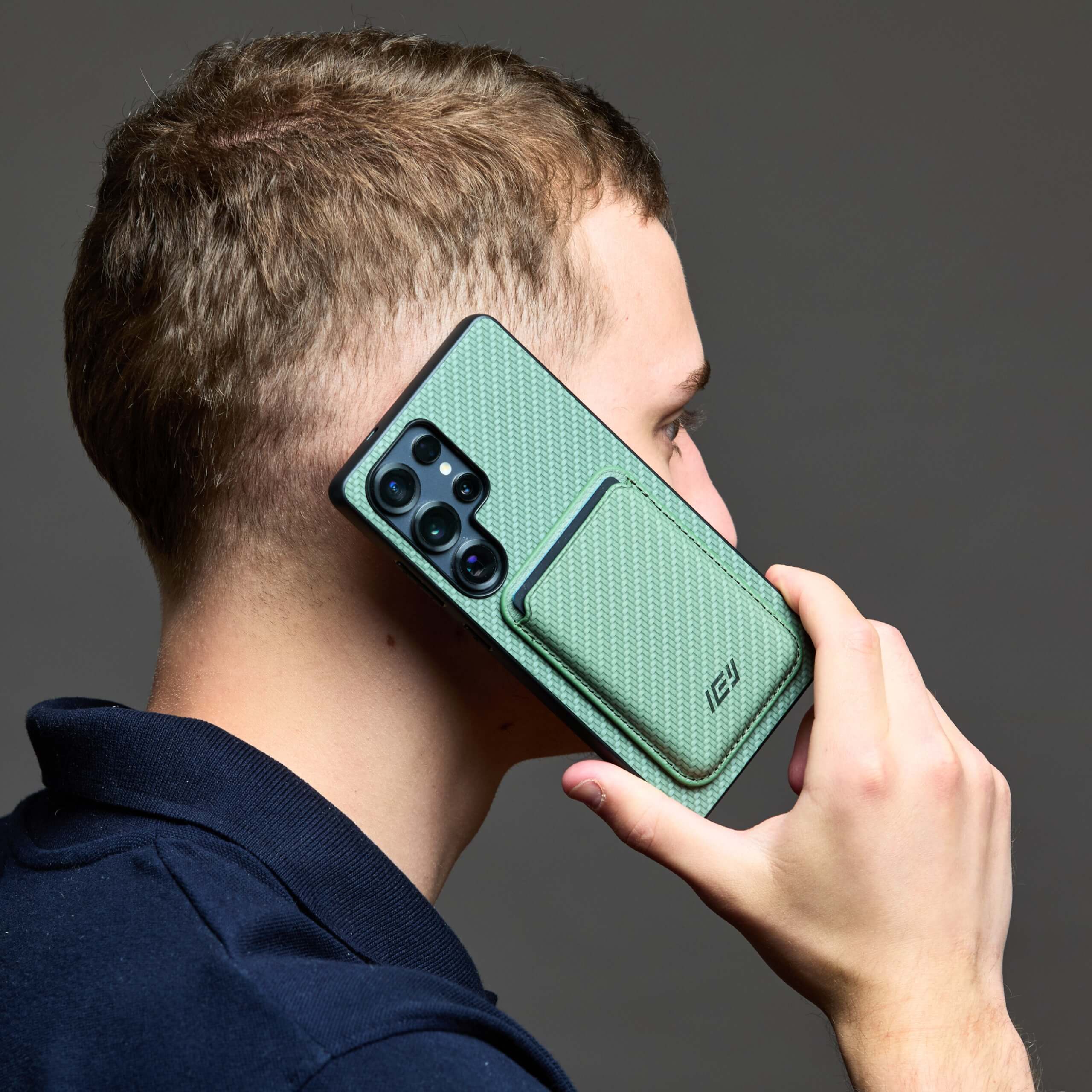 Hombre utilizando funda MagSafe IEY® verde con billetera magnética integrada #color_verde