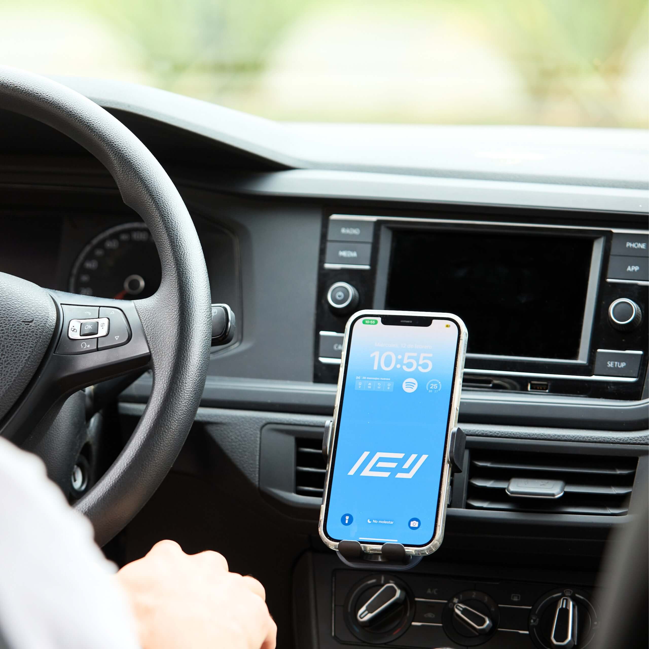 Soporte de celular IEY montado en auto con pantalla principal visible y app Spotify