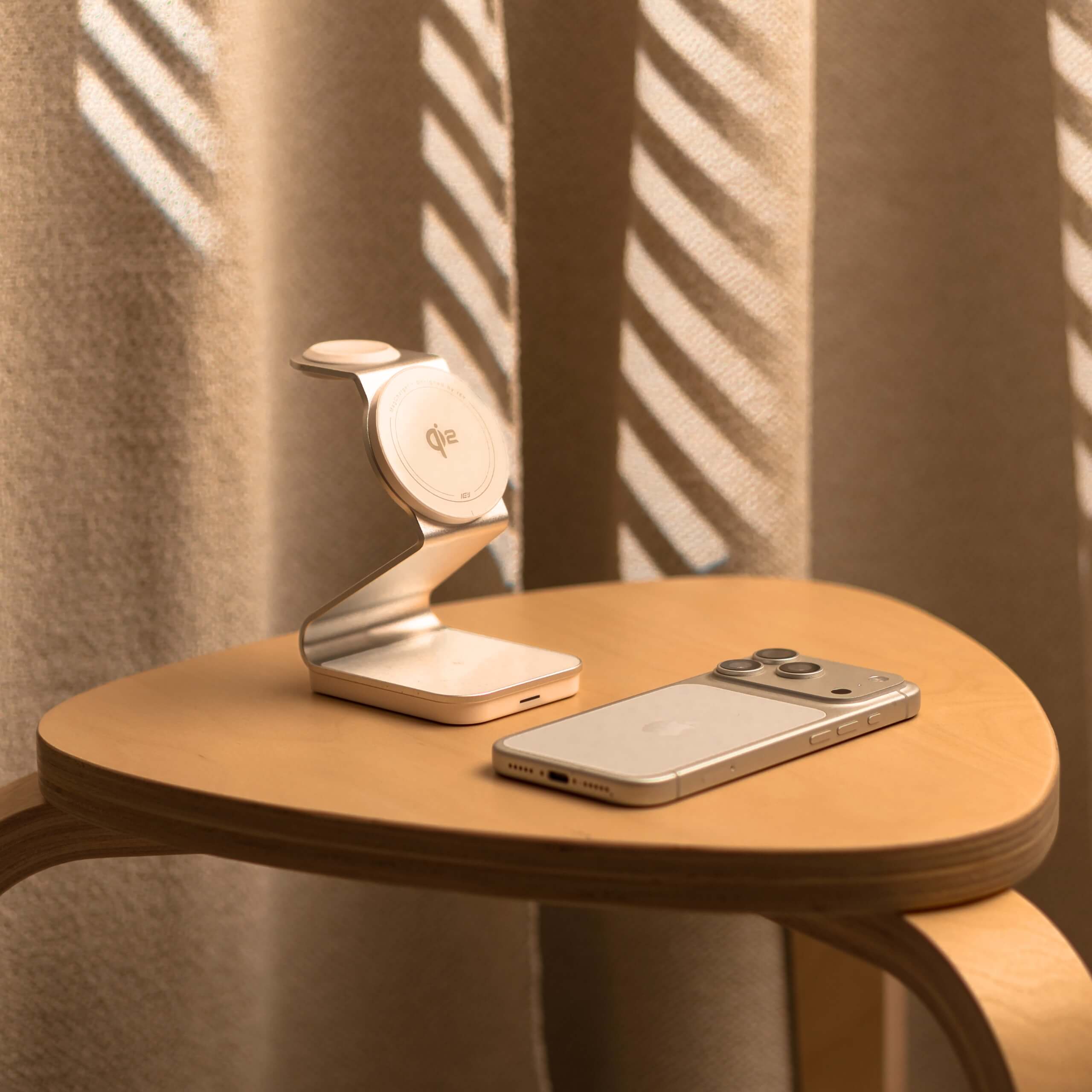 Living minimalista con mesa de madera, iPhone y Estacion de carga Qi2 de la marca IEY con MagSafe