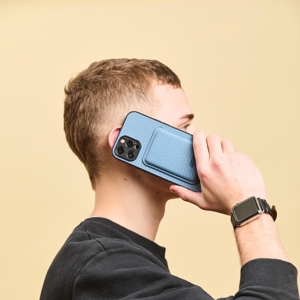 Hombre simulando una llamada con su Iphone con la Funda Magsafe y Billetera MagWallet integrada color azul
