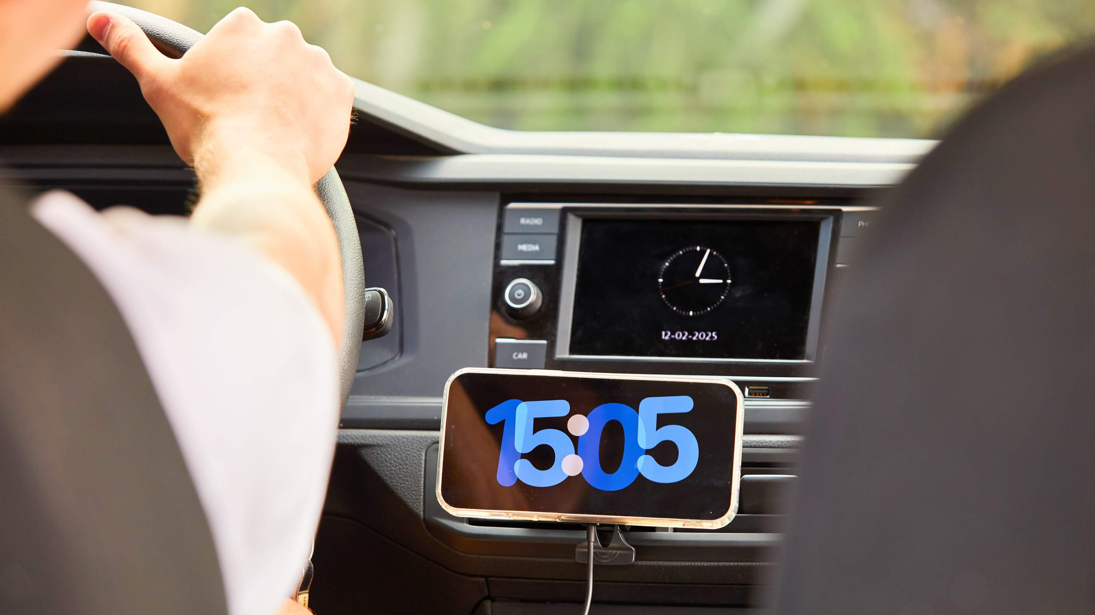 Soporte magnético IEY con smartphone mostrando la hora, montado en rejilla del auto