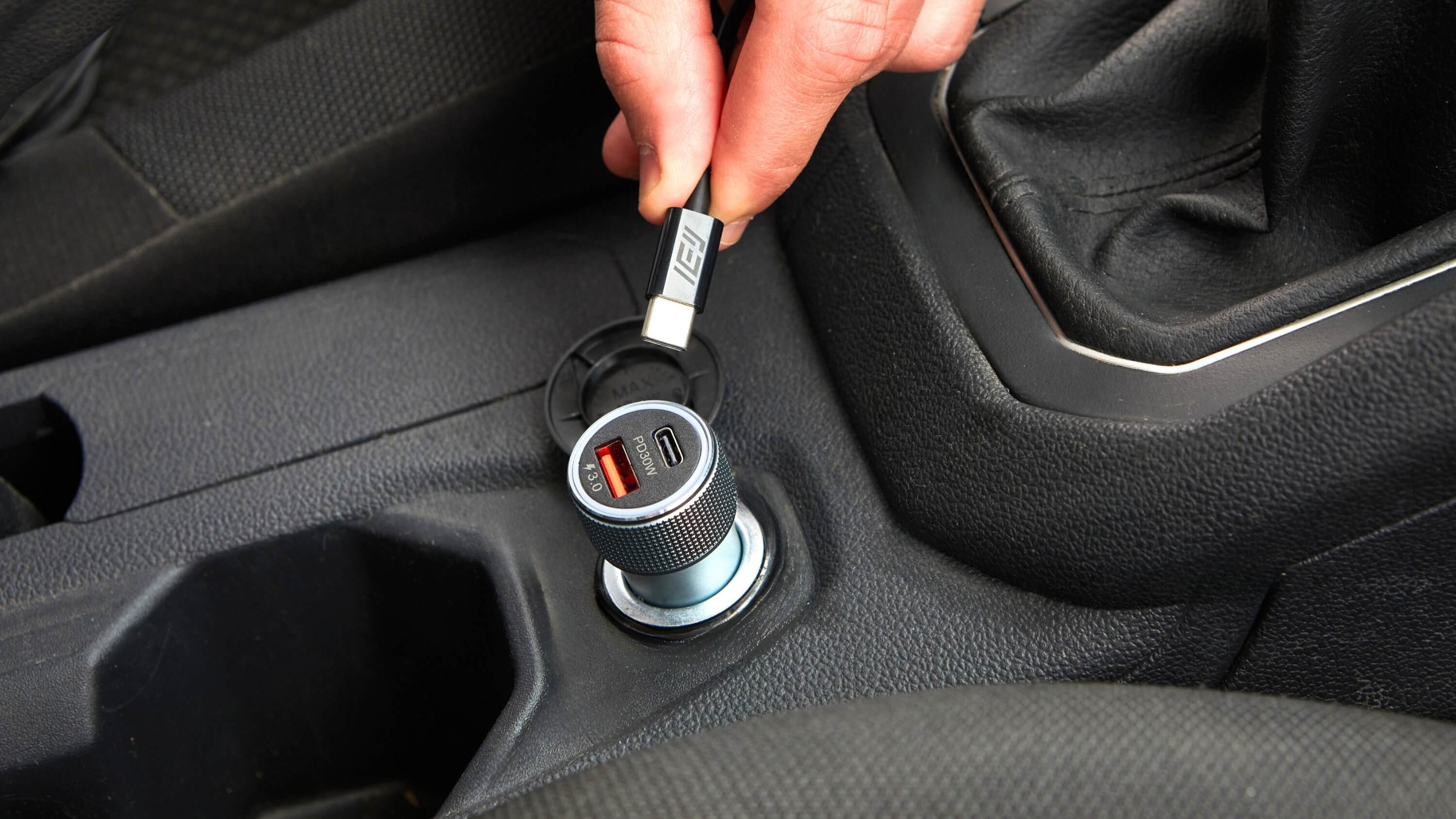 Conector USB-C siendo enchufado al Cargador de Auto IEY de 30W con doble puerto USB-A y USB-C para carga rápida en el vehículo