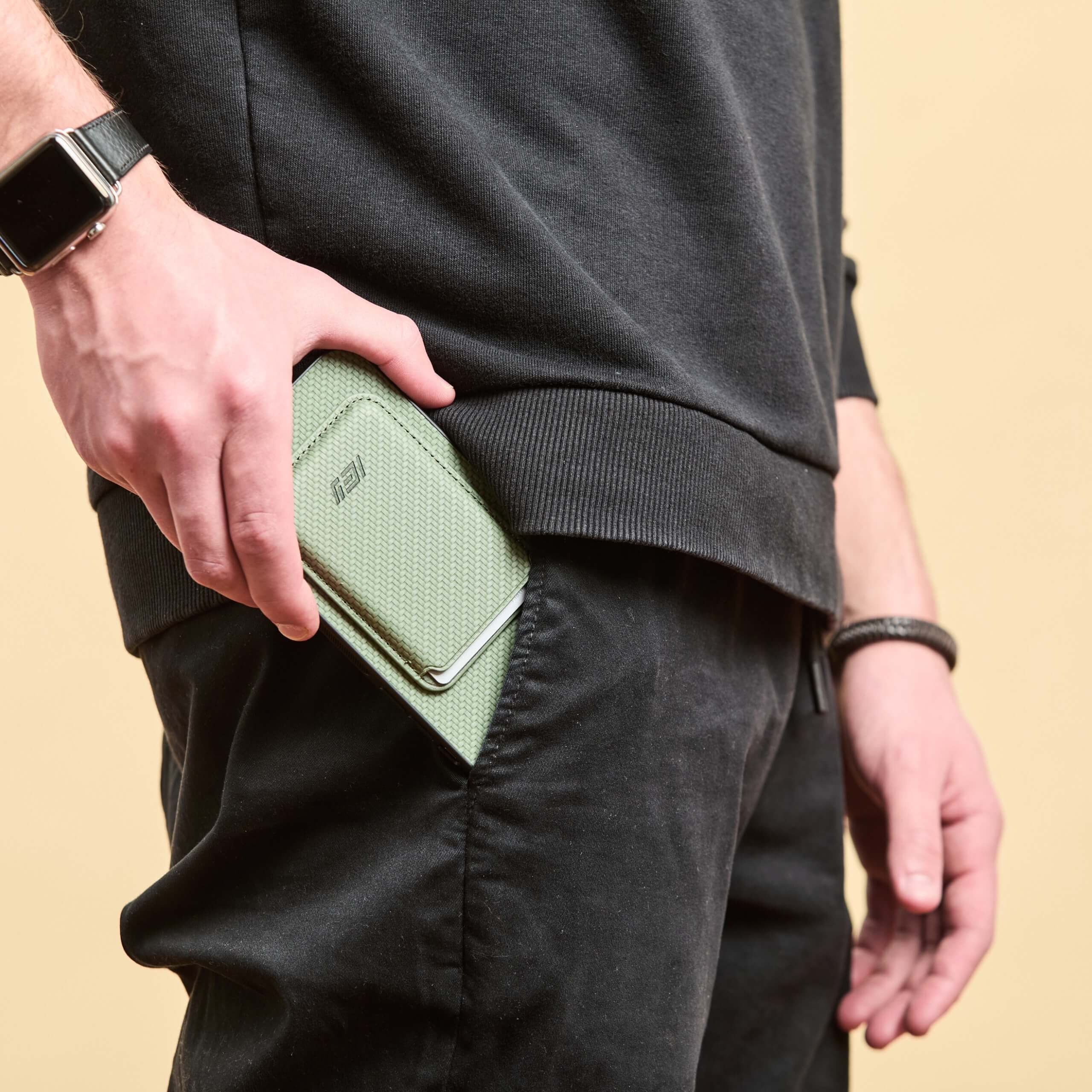 Hombre sacando su Iphone con la Funda Magsafe con Billetera MagWallet color verde del bolsillo lateral de su jean 
 #color_verde