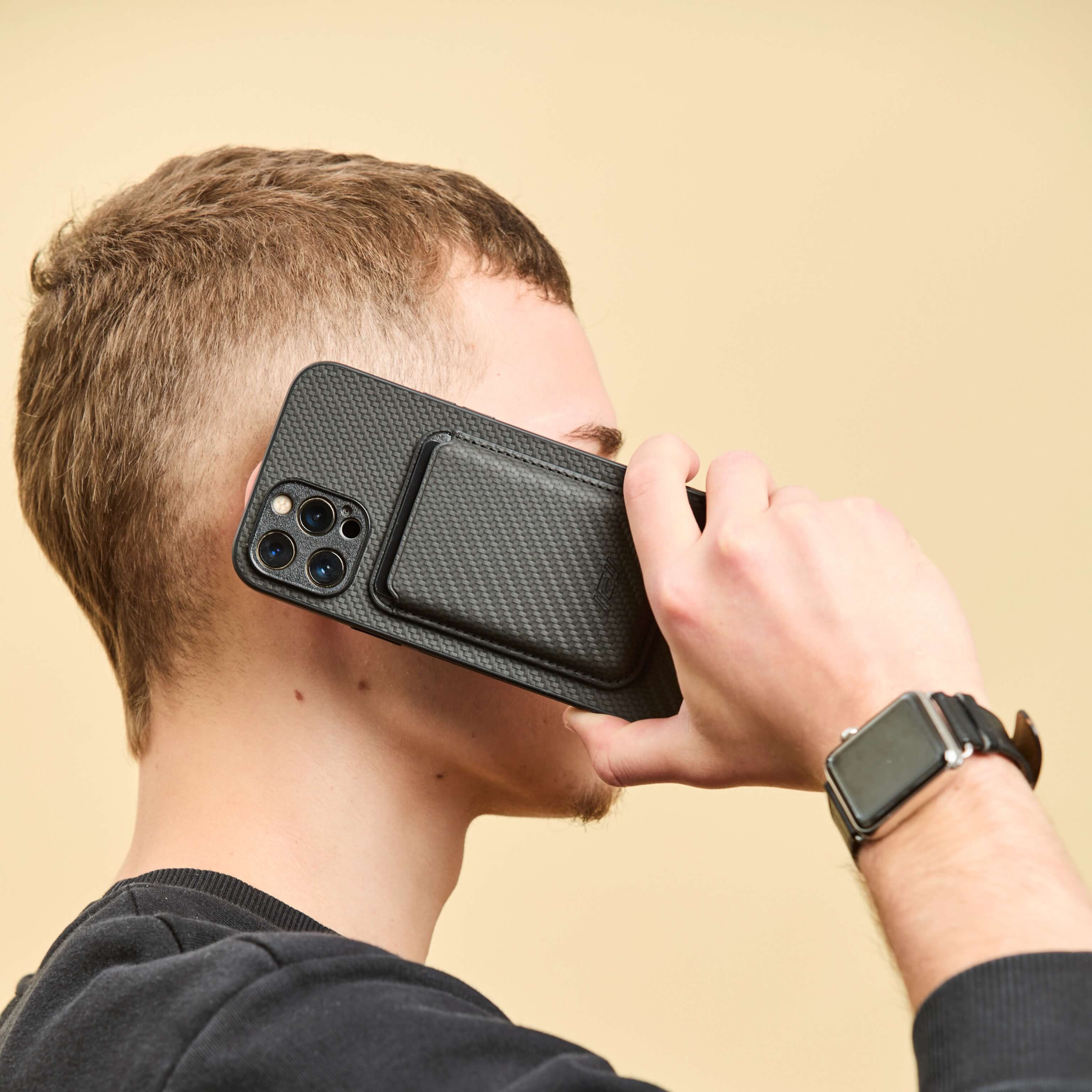 Hombre simulando una llamada con su Iphone con la Funda Magsafe y Billetera MagWallet integrada color negro #color_negro