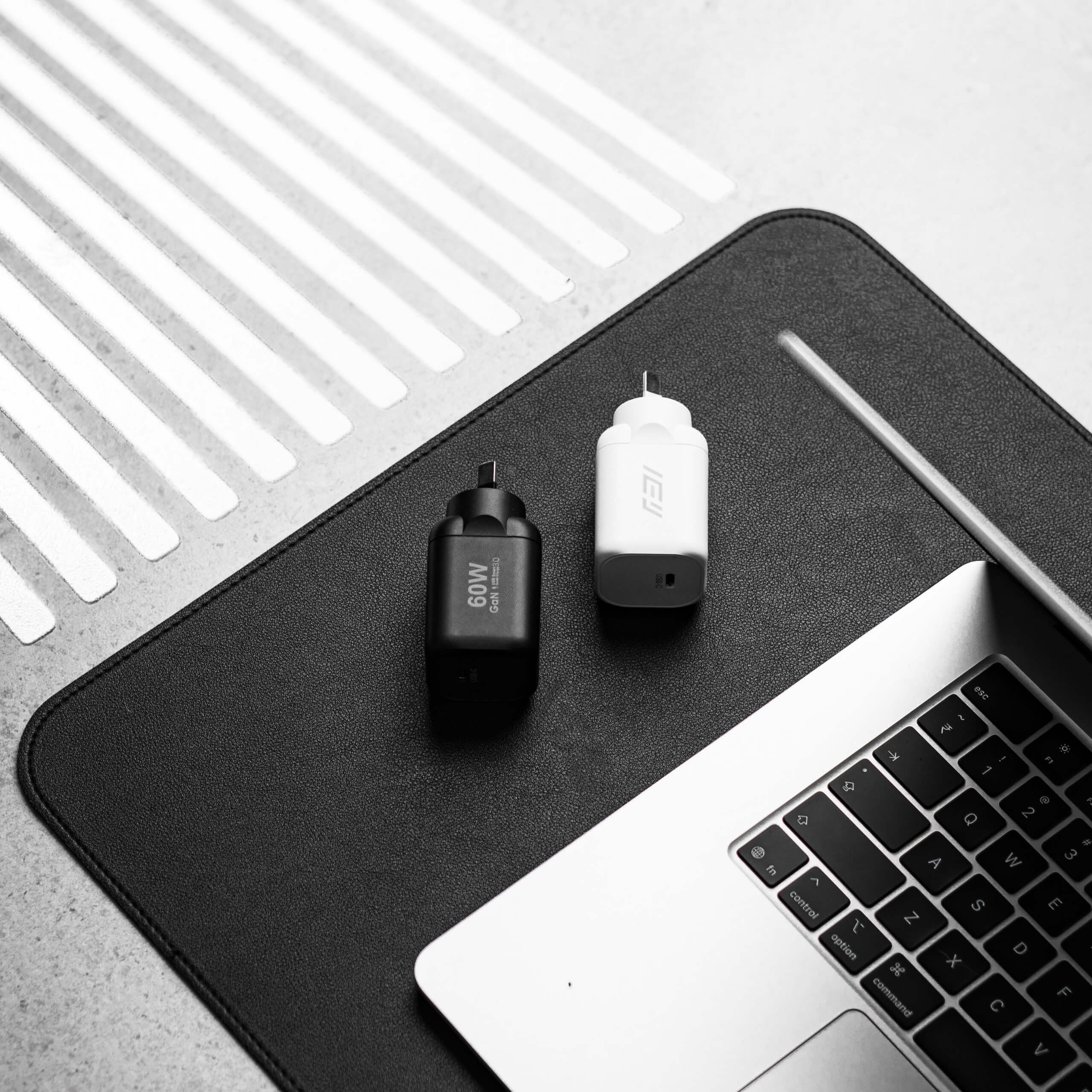 Cargador de pared GaN USB-C 60W IEY® en color blanco y negro junto a notebook sobre escritorio