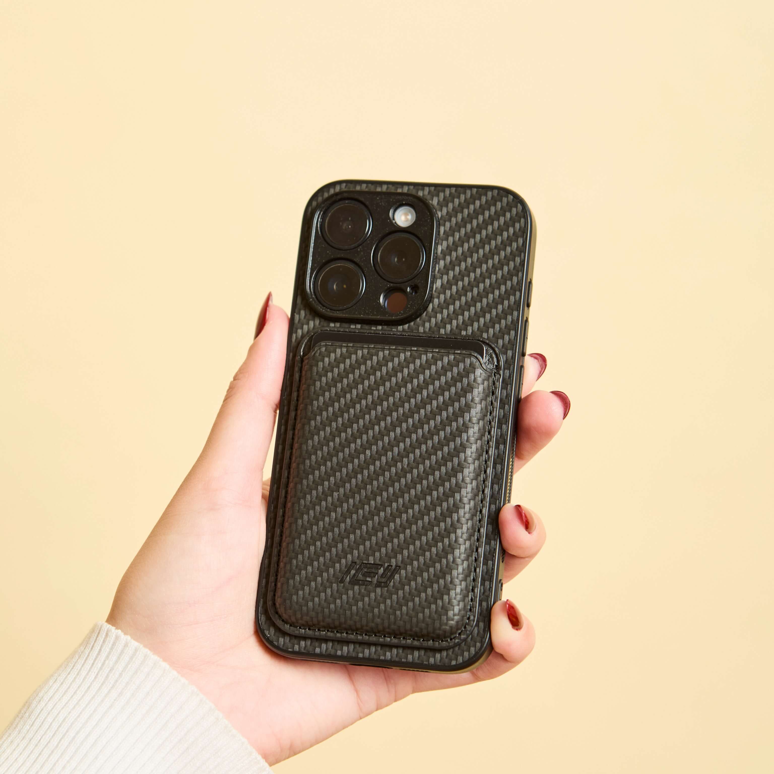 Mujer sosteniendo iphone con Funda Magsafe carbon y Magwallet integrada de color negro #color_negro