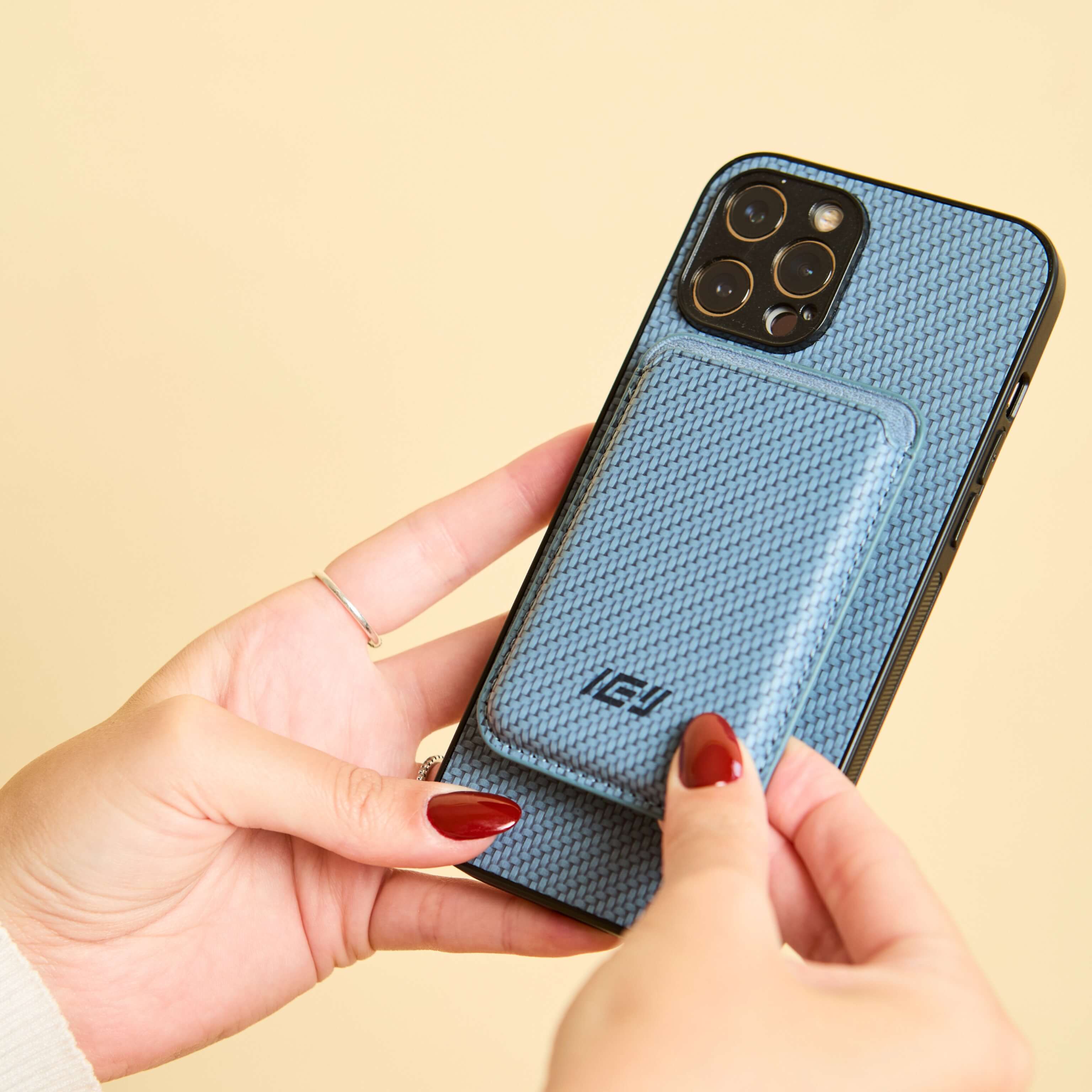 Mujer sosteniendo iphone con Funda Magsafe carbon y Magwallet integrada de color azul #color_azul