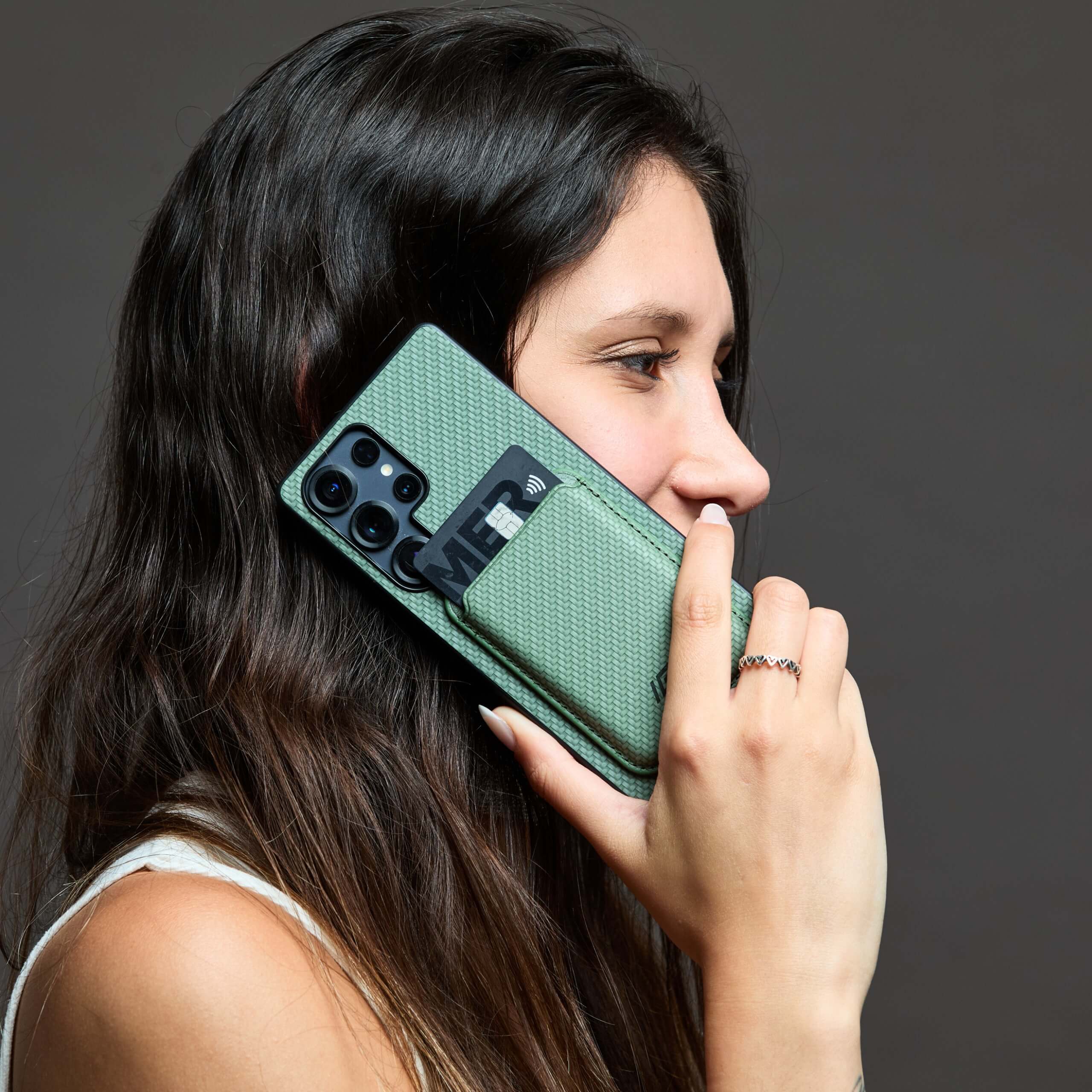 Mujer usando funda MagSafe IEY® verde con wallet magnético en el teléfono #color_verde