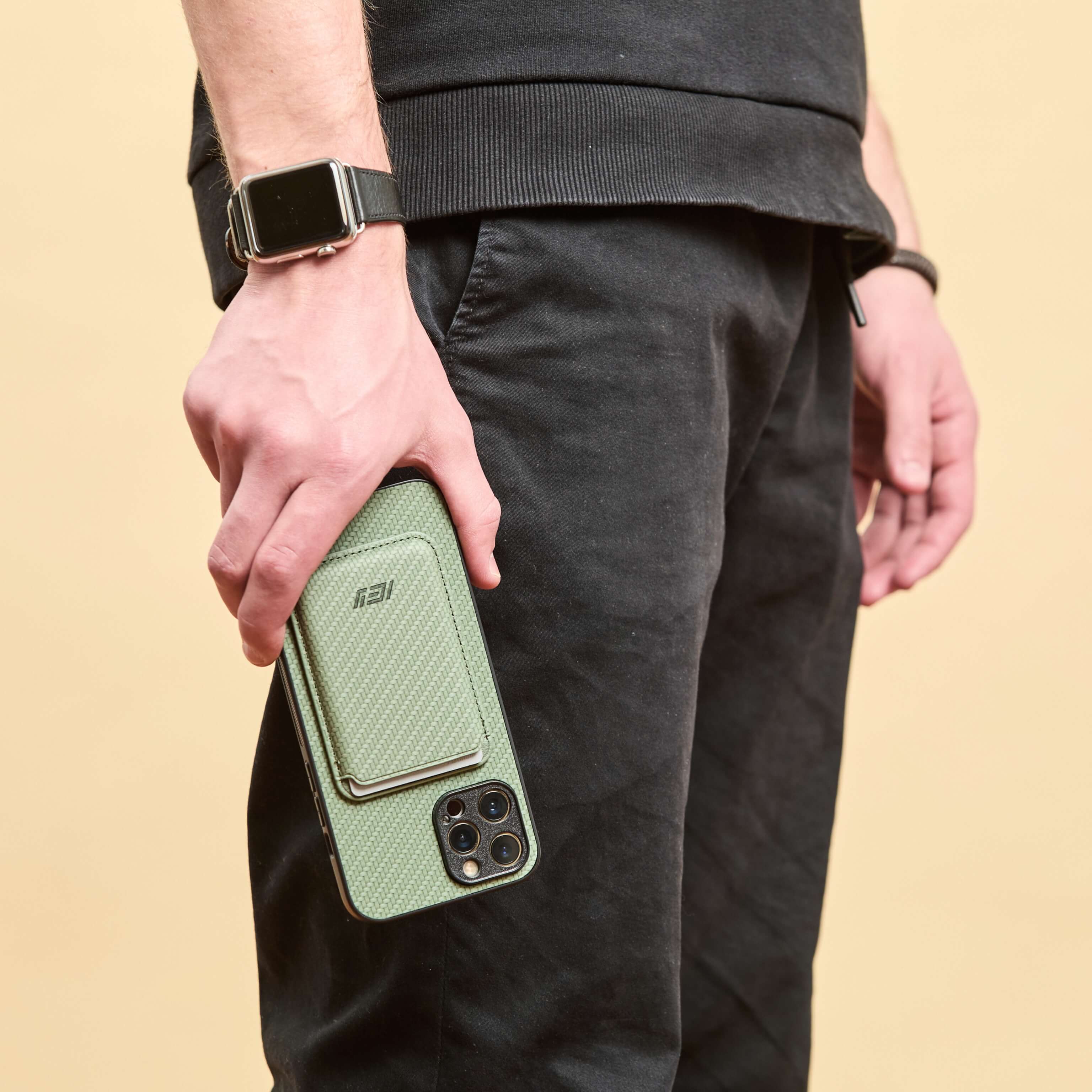 Hombre sosteniendo su Iphone con la Funda Magsafe y Billetera MagWallet  Integrada color verde #color_verde