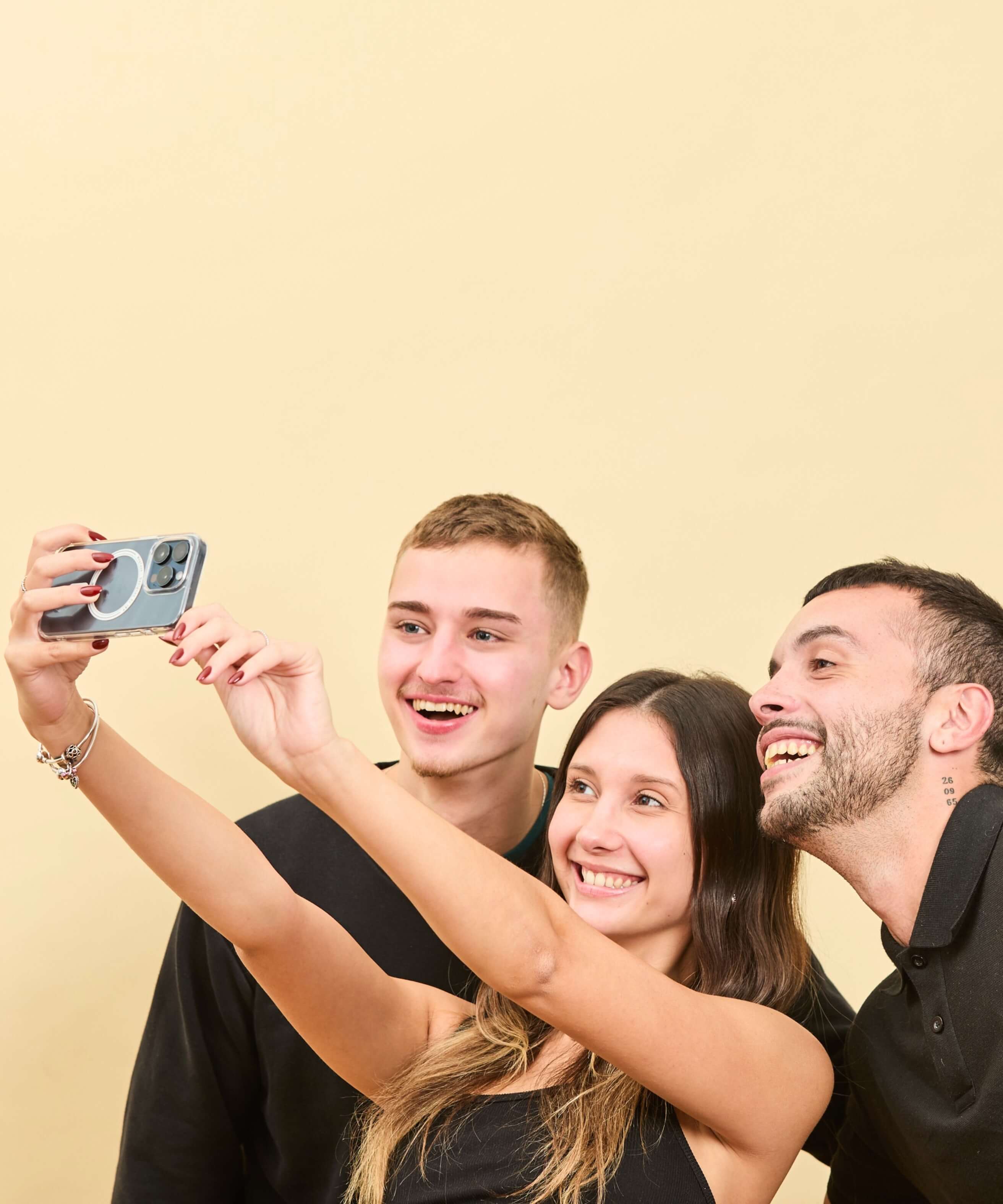 Tres personas sonriendo fotografiandose con su iPhone con Funda MagSafe Transparente