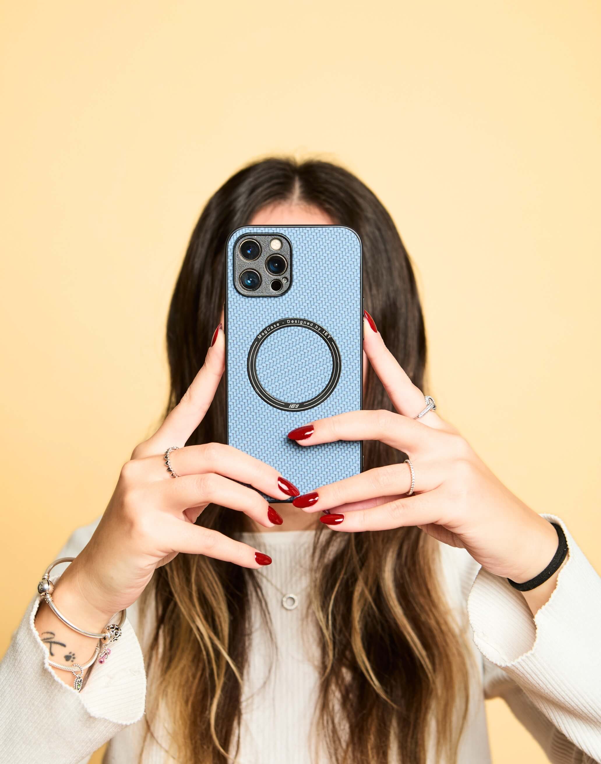 Mujer sosteniendo su iPhone con Funda MagSafe Carbon color azul