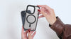 Funda MagSafe negra para iPhone, con aro imantado visible y bordes elevados de protección para cámara